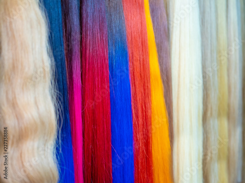 Multicolored strands of artificial hair. Hairdressing salon. Hair care. Hair extensions.