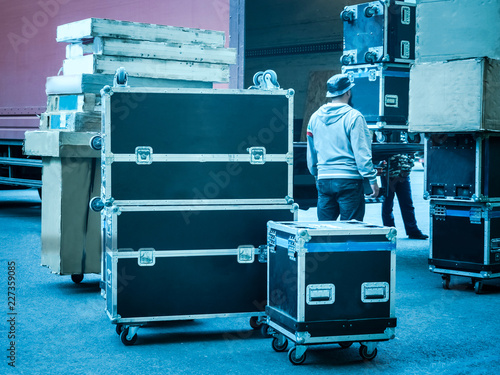Loading and unloading of concert equipment. Loading equipment in a van. Man controls the loading of equipment cases.