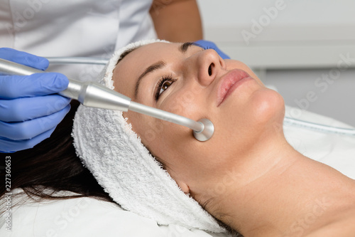 Young woman enjoying skin rejuvenation therapy at cosmetology center.