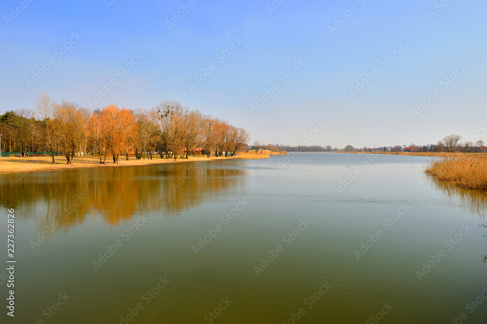 Jezioro w pogodny jesienny dzień z drzewami na brzegu.