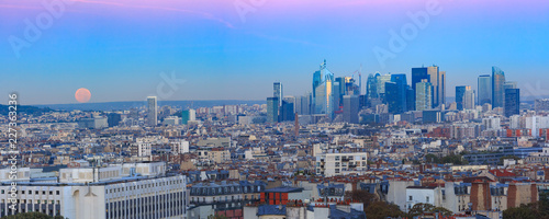 Aerial panoramic view from Montmartre over Paris roofs and La Defense business district with full moon at sunrise  Paris  France