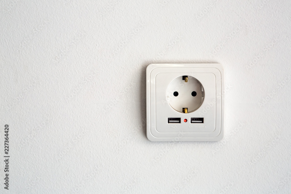 universal power socket European standard 220 volt with two connectors usb for charging mobile devices. socket white plastic on a white wall with copy space for text. universal power socket European standard 220 volt with two connectors usb for charging mobile devices. socket white plastic on a white wall with copy space for text.
