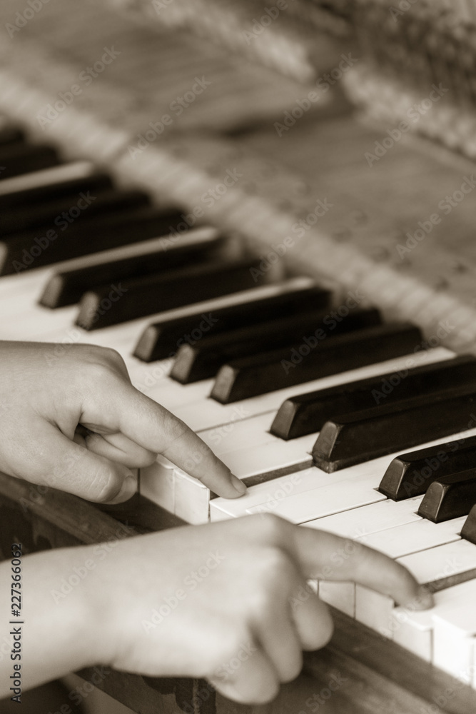 Fototapeta premium Little girl playing on the piano