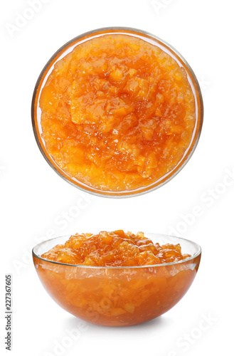 Set with bowls of delicious peach jam on white background