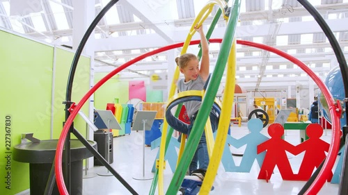 Young girl having fun on human gyroscope at a science centre photo