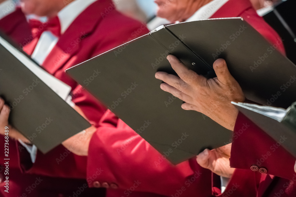 Mens choir members holding singing book