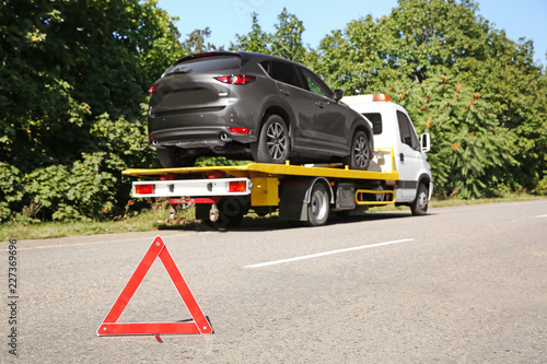 Canvastavla Emergency stop sign with broken car and tow truck on background