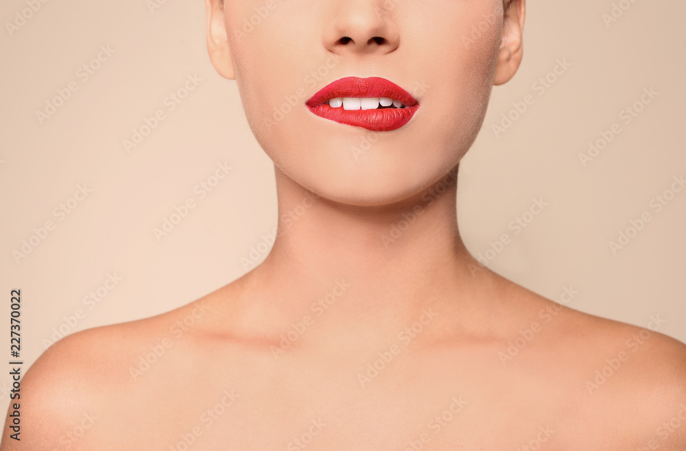 Beautiful young woman with red lips on color background, closeup
