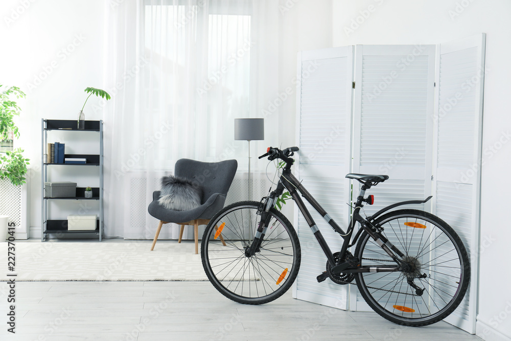 New bicycle near folding screen in stylish room interior New bicycle near folding screen in stylish room interior