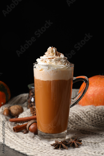 Glass cup with tasty pumpkin spice latte on table