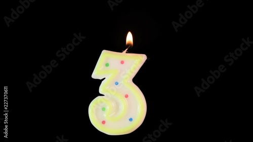 Wax candle in shape of number 3 burns. A nice addition to your birthday video. Made with alpha matte - background is transparent. photo