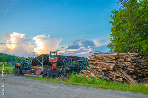 working old tractor in lumber yard with barn with beautiful sky