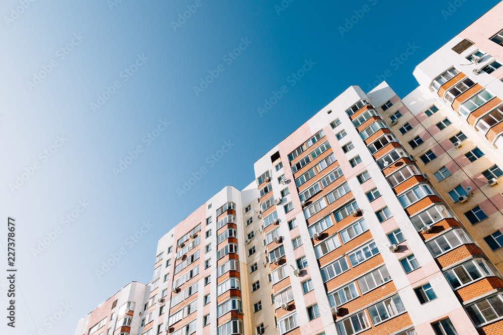 multi-colored multi-storey high-rise residential building against the blue sky