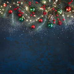 Christmas background with fir twigs, red berries, cones and Xmas lights on dark, copy-space