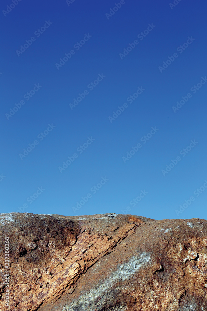 Close up image of boulder against blue sky Close up image of boulder against blue sky