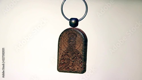 Close Up of the Saint Basil Icon Wooden Souvenir Keychain. The Light Moves From Right to Left. photo