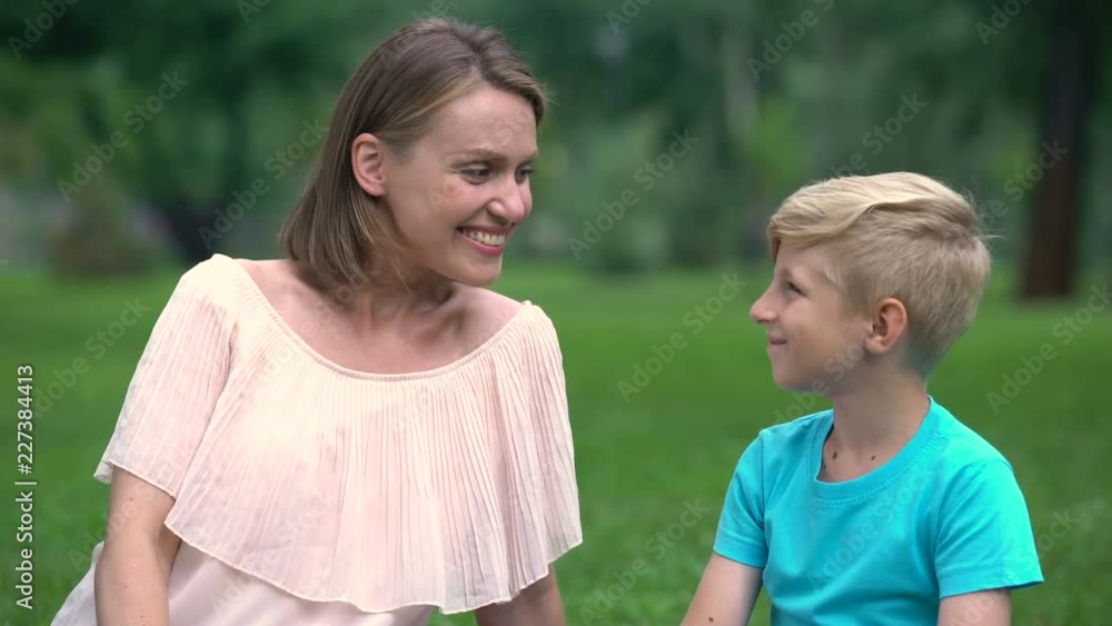 Mother and son nuzzling, spending time together outdoors, unity of loving family