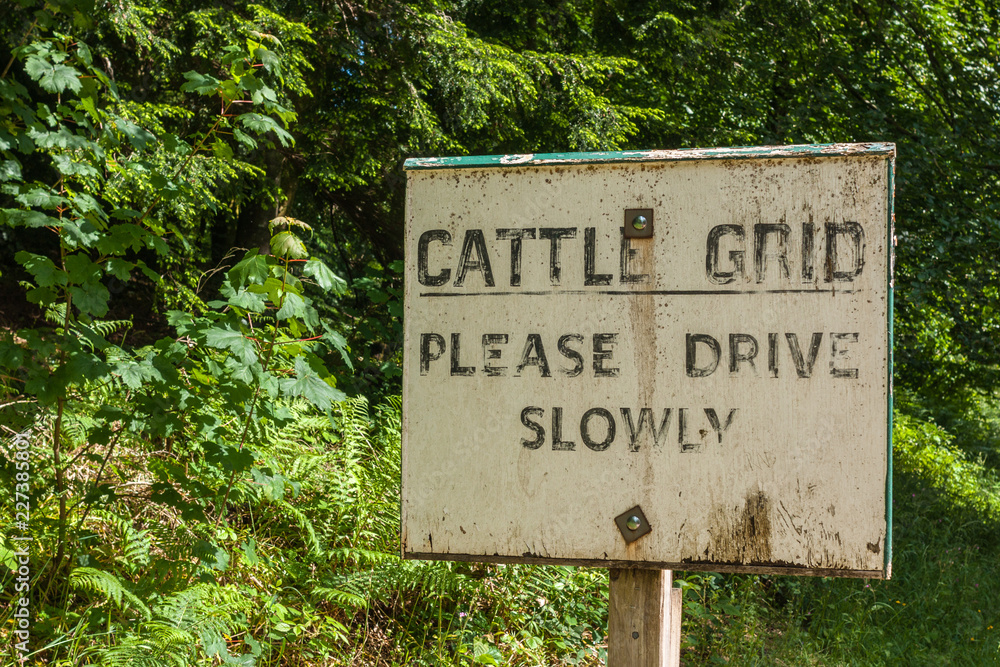 Holm of Drumlanrig, Scotland, UK - June 18, 2012: Closeup of black on white old cattle grid sign along the road. Holm of Drumlanrig, Scotland, UK - June 18, 2012: Closeup of black on white old cattle grid sign along the road.