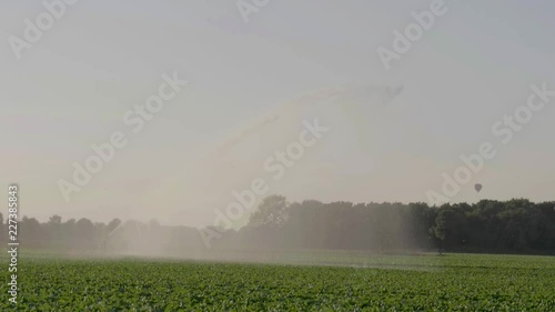 180 fps - Large sprinkler creating rainscreen over crops photo