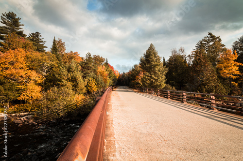 Bridge over Raquette River surrounded by brillant fall foliage in Long Lake NY, ADK Mountains photo