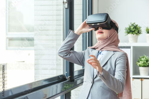 confident Muslim office worker wearing VR technology glasses photo