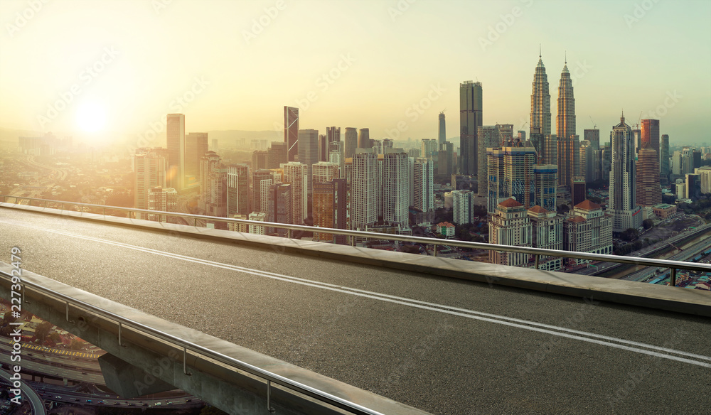 Empty asphalt flyover  road with modern cityscape skyline , sunrise scene .