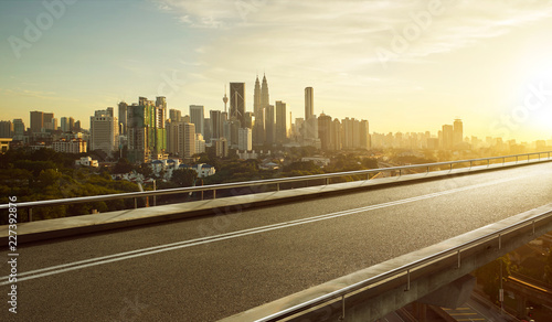 Empty asphalt flyover  road with modern cityscape skyline   sunrise scene .