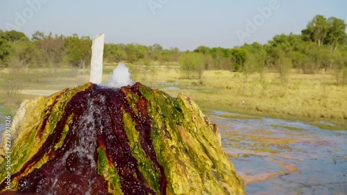 Close up of natural hot spring in the remote Australian outback. Spring has bubbling water and visible steam flowing from colourful mound of minerals. Location Burketown, Queensland, Australia. photo