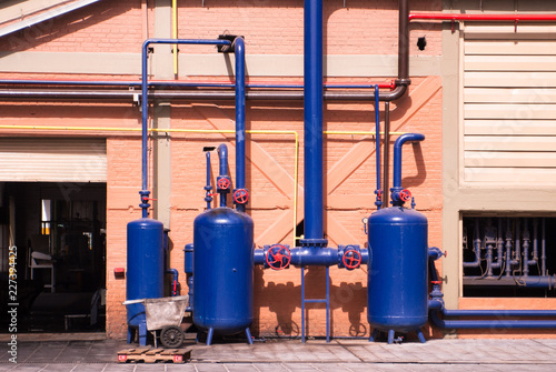 Blue air compressed tanks outside factory. Industrial equipment
