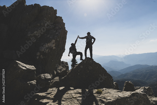 two successful climbers on the rock and joyful position