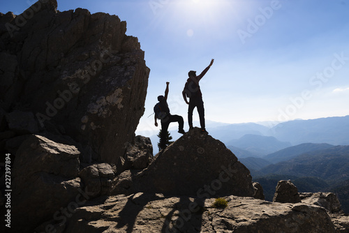 concept of two successful people at the top of the mountains