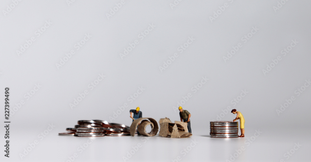 A pile of coins and miniature people. A pile of coins and miniature people.