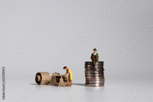 A pile of coins and miniature people. A concept of profit and poverty. photo