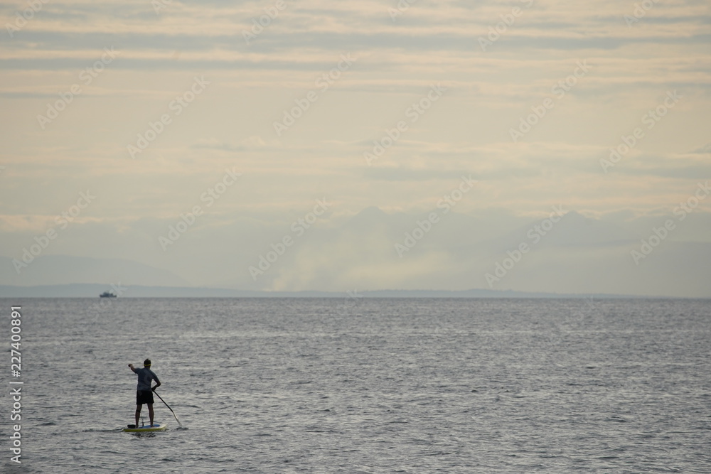 Naklejka premium man on a paddle board in the sea