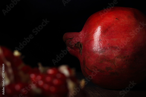 гранат свежий фрукт раскрытый лежит на ярком фоне 