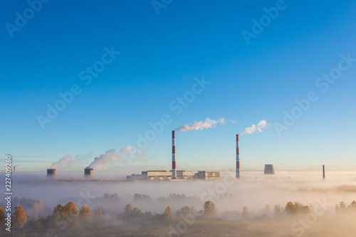 The cooling towers and pipes or tubes of thermal power station in the clear autumn sunny day