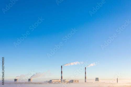 The cooling towers and pipes or tubes of thermal power station in the clear autumn sunny day