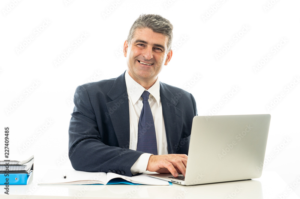 Attractive happy mature caucasian businessman working on laptop computer on desk at office Attractive happy mature caucasian businessman working on laptop computer on desk at office