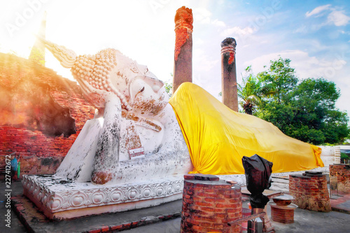 Big white cement buddha statue wearing a yellow coat and pagoda with sunlight at Wat Yai Chaimongkol (Chaimongkhon), Phra Nakhon Si Ayutthaya, Thailand. Beautiful of historic city at buddhism temple photo