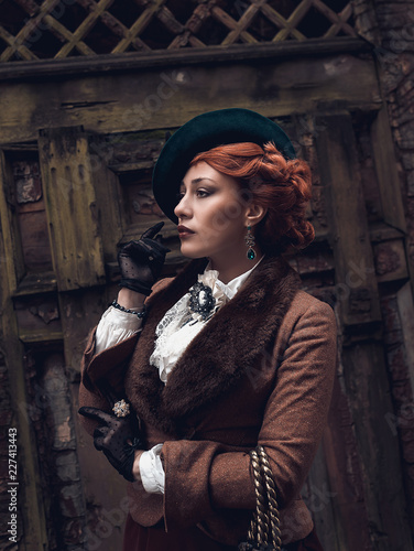 Beautiful woman face in the hat and red hair
