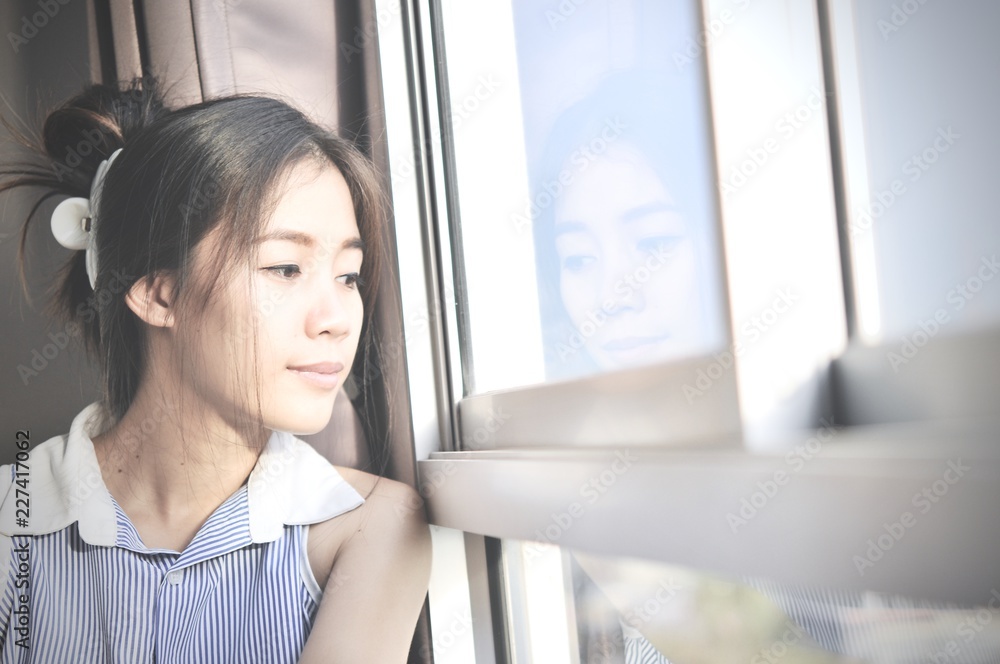 Have a nice day! Close up of Young smart successful smiling woman in the morning and having a happiness, while sitting near window and dreaming.