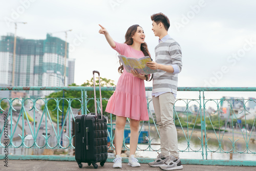 Canvastavla Happy asian couple on vacation sightseeing city with map