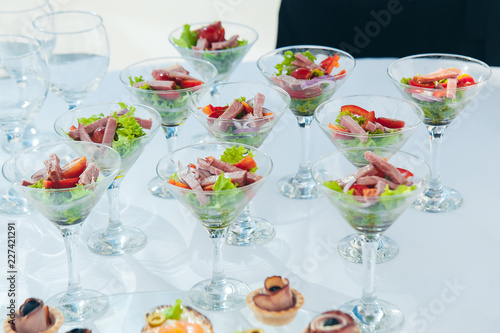wine glasses with salad and meat snack at reception. catering snack service