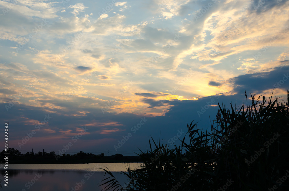 Obraz premium Yellow and red sunset over a calm river