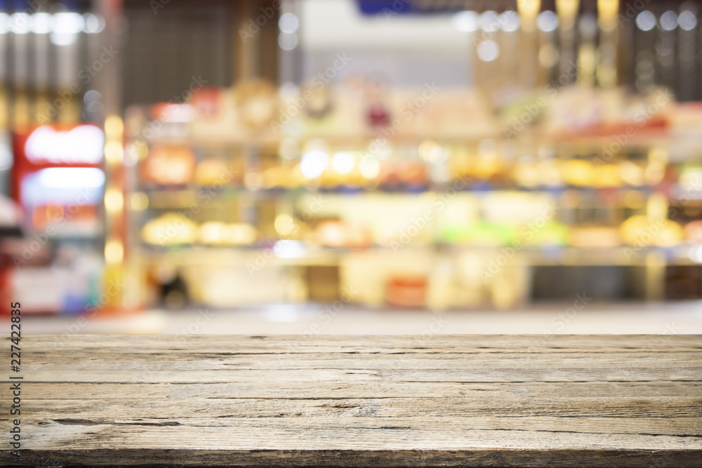 Wooden table with blur background of coffee shop.