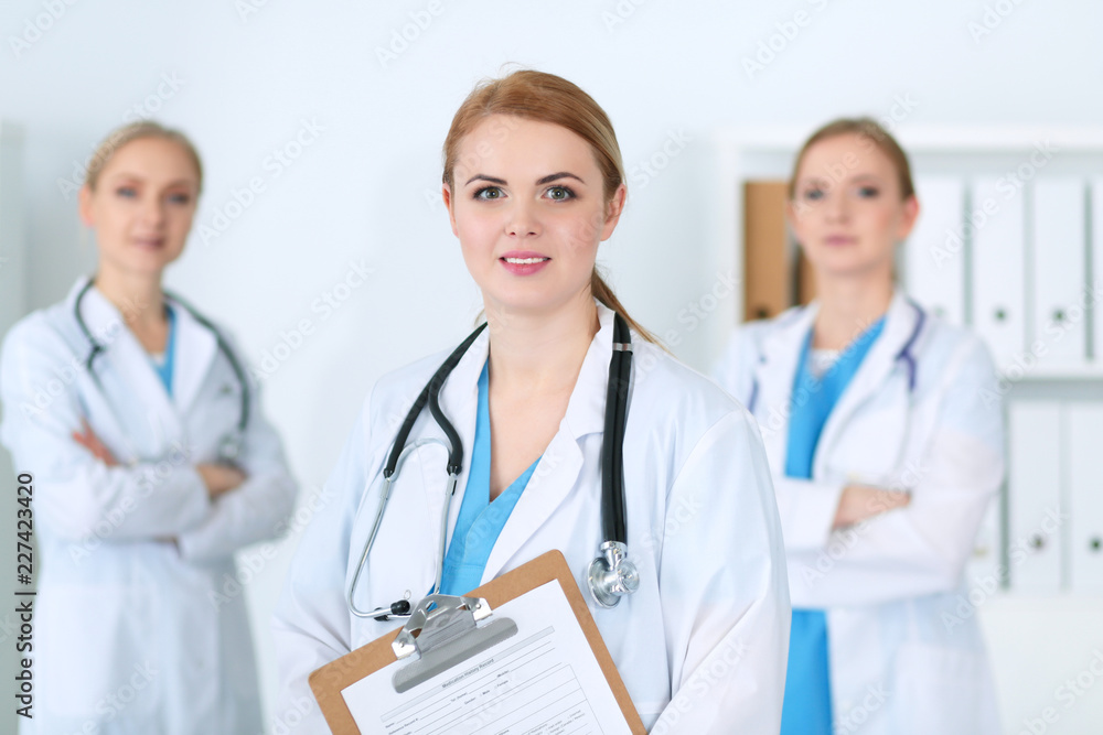 Group of medical doctors standing at hospital. Team of physicians ready to help patients. Medicine and health care concept Group of medical doctors standing at hospital. Team of physicians ready to help patients. Medicine and health care concept