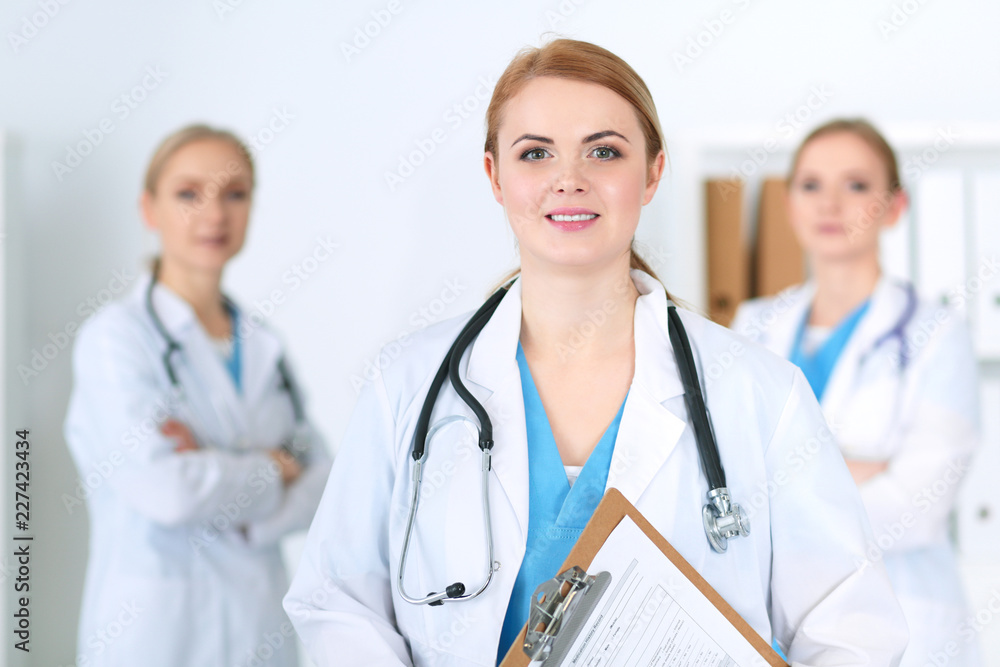 Group of medical doctors standing at hospital. Team of physicians ready to help patients. Medicine and health care concept Group of medical doctors standing at hospital. Team of physicians ready to help patients. Medicine and health care concept