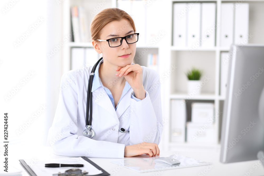 Young brunette female doctor at work in hospital. Physician ready to help. Medicine and healthcare concept Young brunette female doctor at work in hospital. Physician ready to help. Medicine and healthcare concept