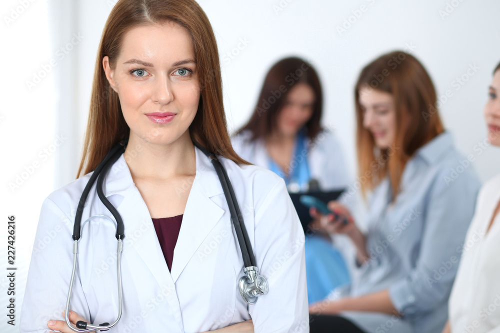 Young beautiful female doctor smiling while consulting her patient. Physician at work. Medicine and healthcare concept Young beautiful female doctor smiling while consulting her patient. Physician at work. Medicine and healthcare concept
