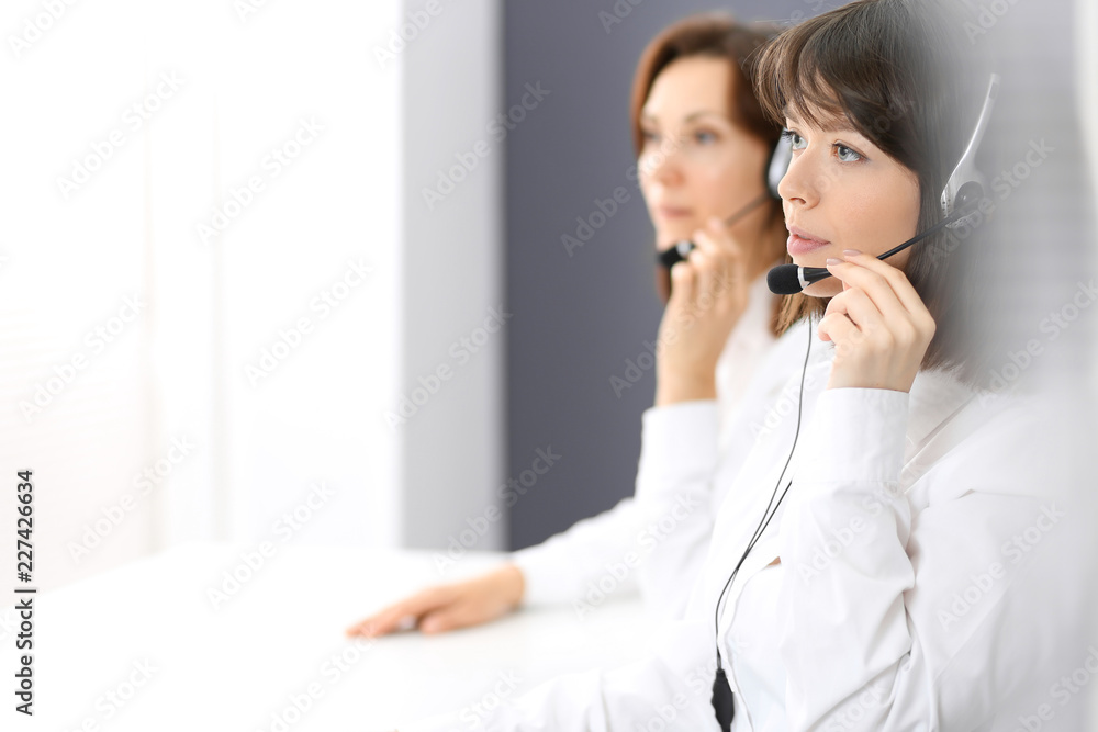 Call center. Group of operators at work. Focus on young brunette woman. Business concept Call center. Group of operators at work. Focus on young brunette woman. Business concept